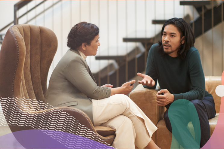 Two people sitting down talking