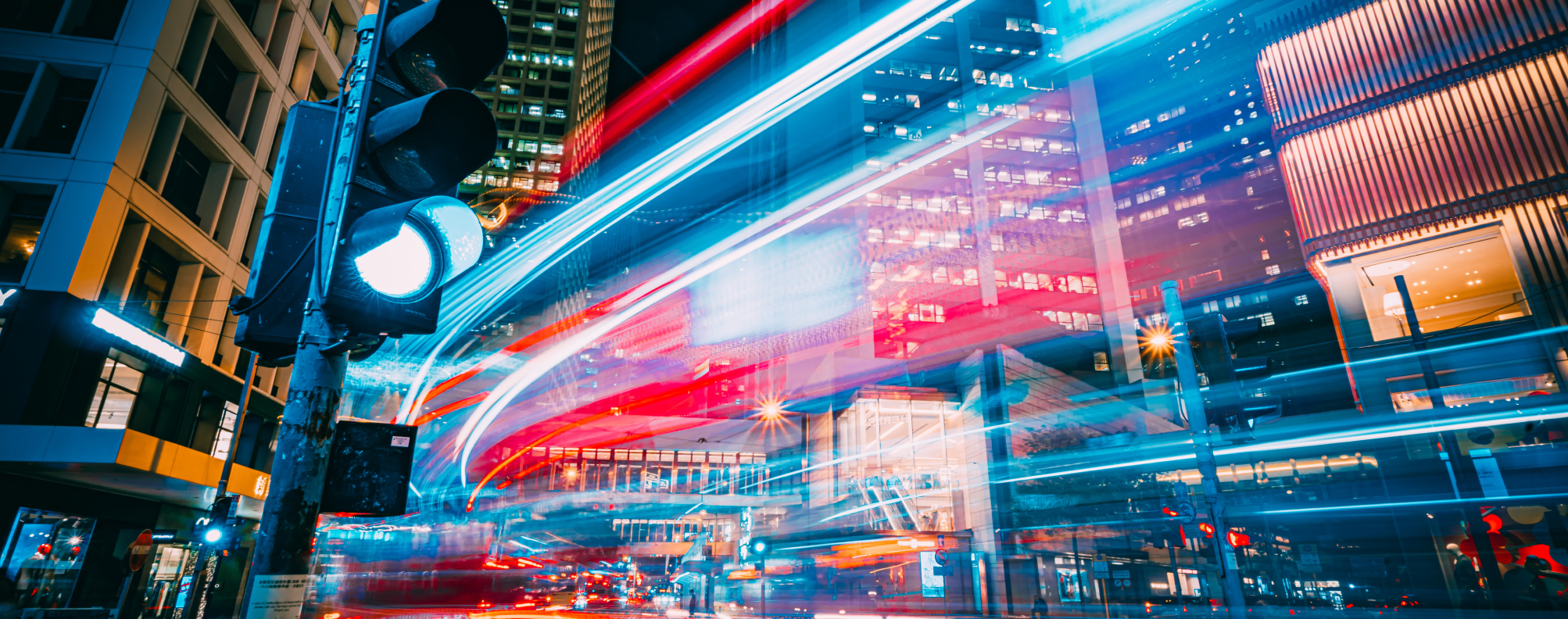 Long exposure of a city street with vehicle lights streaming past.